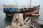 Foto, Bild: aus einer arabischen Dau im altem Hafen von Mobasa wird Trockenfisch entladen