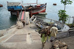 Foto, Bild: aus einer arabischen Dau im altem Hafen von Mombasa wird Trockenfisch entladen