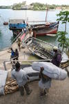Foto, Bild: aus einer arabischen Dhau im altem Hafen von Mombasa wird Trockenfisch entladen
