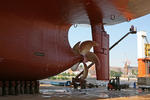 Foto, Bild: Malerarbeiten an der Bordwand mit Schiffsschraube und Ruder bei Blohm + Voss Repair